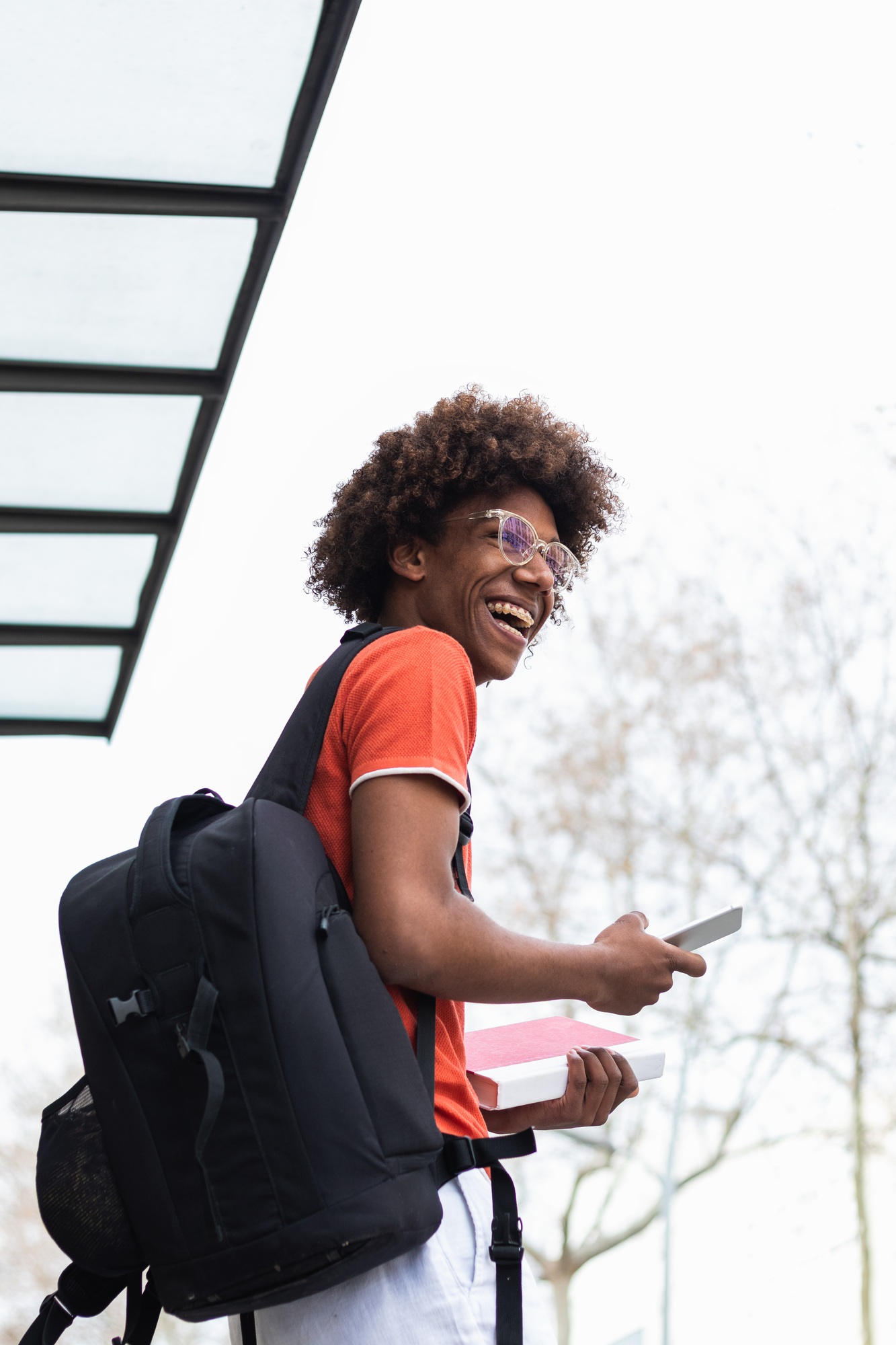 Smiling African American student using smartphone